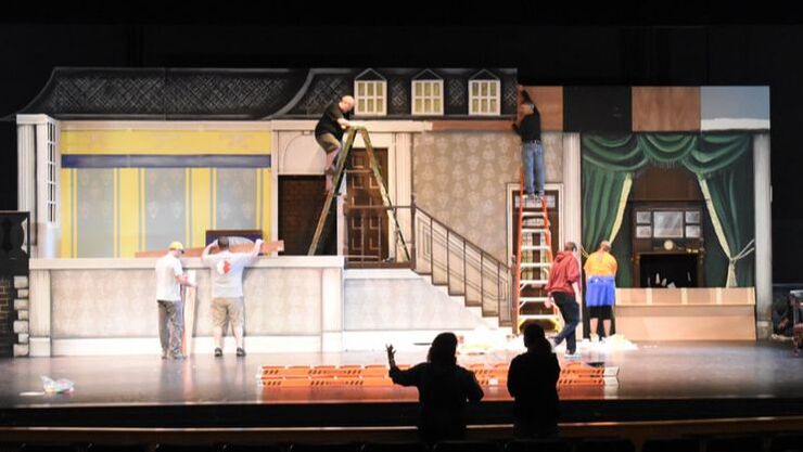 Volunteers assemble the set for Mary Poppins